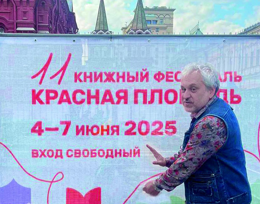 Книжный фестиваль на Красной площади, автор на стенде раздает закладки, посетители выбирают книги, июнь 2025 Москва